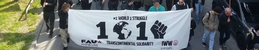 Global May Day. Demonstranter med en banderoll. 