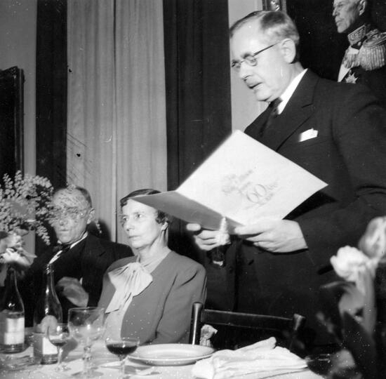 Elise Ottesen-Jensen vid 60 årsdagen på restaurang Piperska muren. Professor Einar Tegen läser upp hyllningsadressen och överlämnar den subskriberade penninggåvan på 5000 kronor (foto 2 januari 1946, publicerad 3 januari 1946).